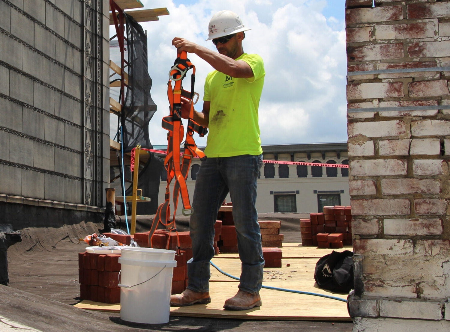 Harnesses scaled|A construction worker using a full-body harness, lanyard and connector on stairs at a jobsite
