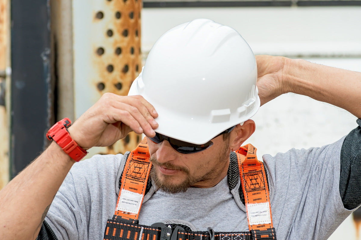 Construction worker adjusting hard hat