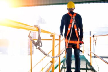 Construction worker use safety harness and safety line working on a new construction site project.