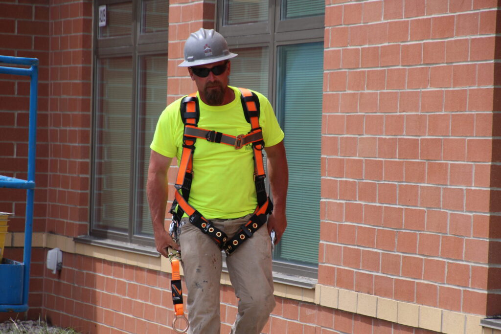 construction worker on site wearing safety harness and helmet
