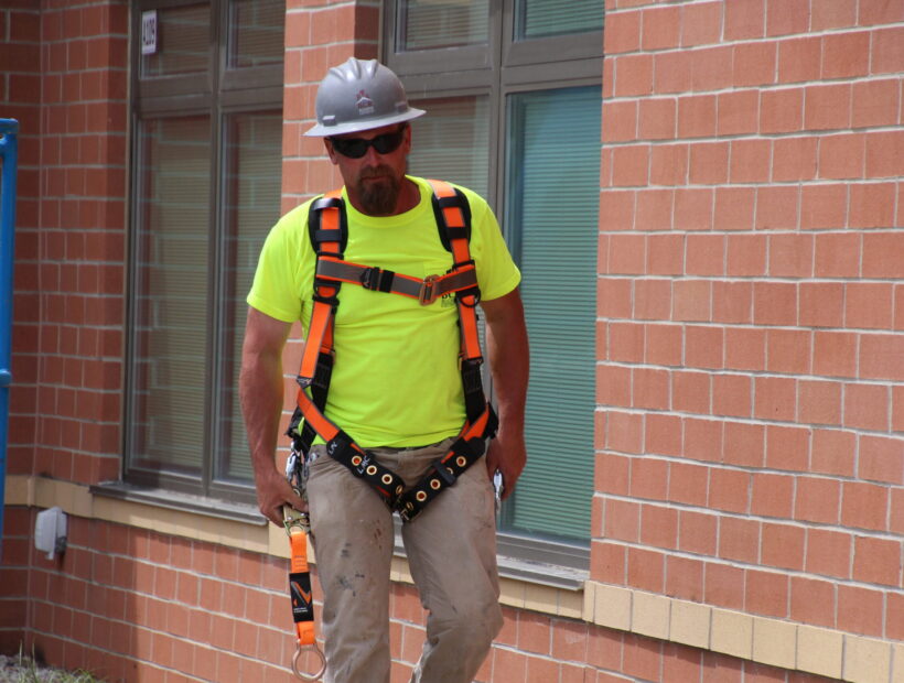 construction worker on site wearing safety harness and helmet